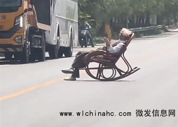 大爷躺马路中间晒太阳 车辆纷纷避让
